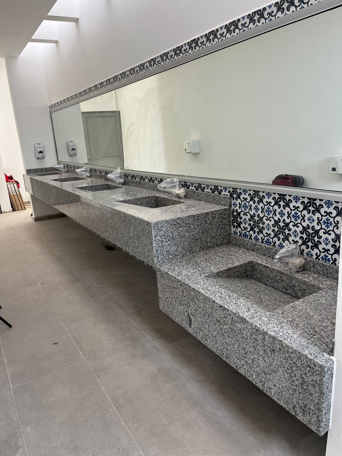 Vanity corrido de granito con lavabos esculpidos y Talavera